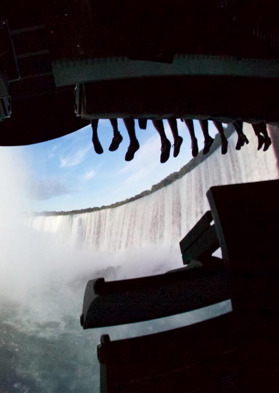 A view from below a flight ride in front of a screen of Niagara Falls