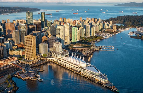Aerial view of Vancouver showing skyscrapers on a peninsula.