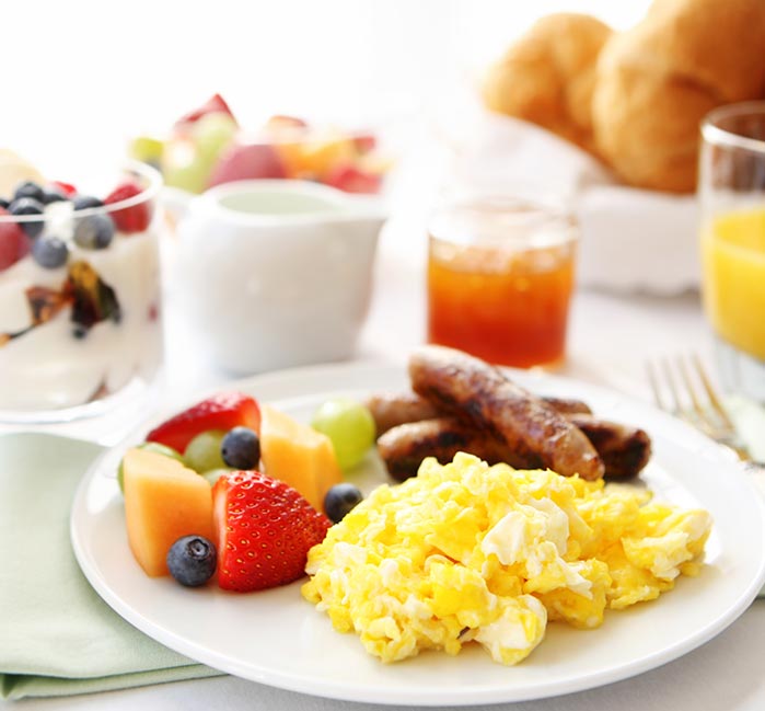A breakfast plate full of food on a table with other items