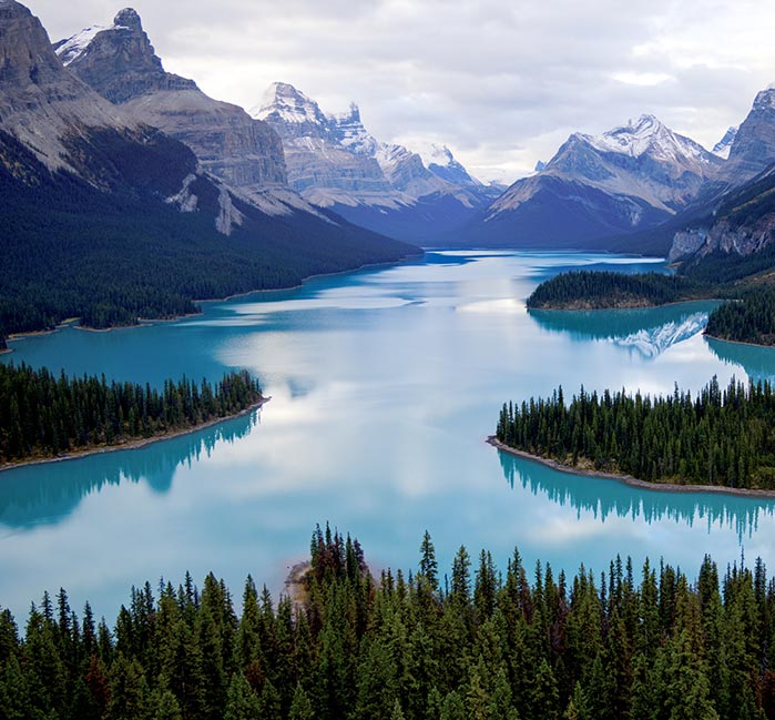 Canadian Rocky mountain vista with a lake and shoreline beneath it.