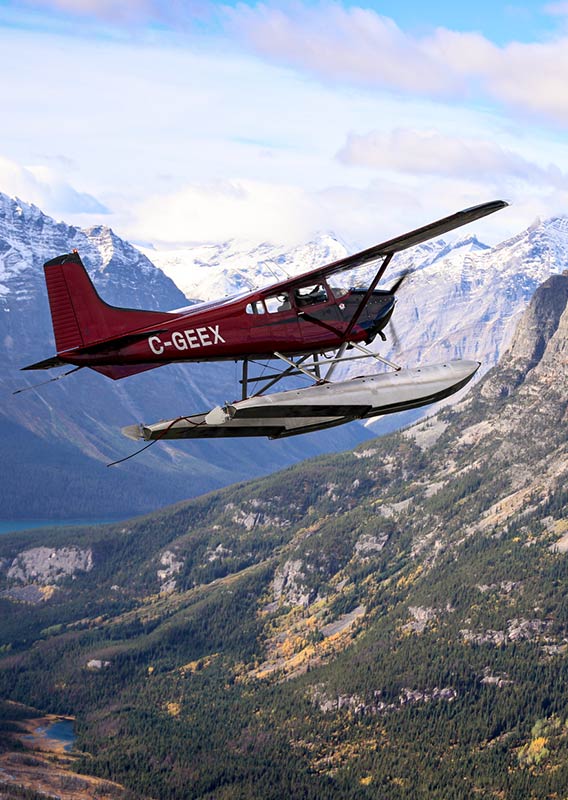 A small plane flies over the Canadian Rocky Mountains